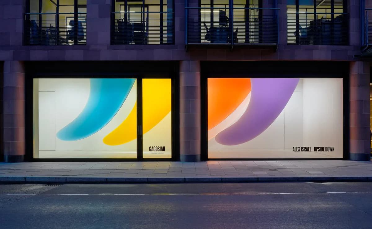 Gagosian gallery storefront at night with two illuminated display windows showing colorful abstract artworks