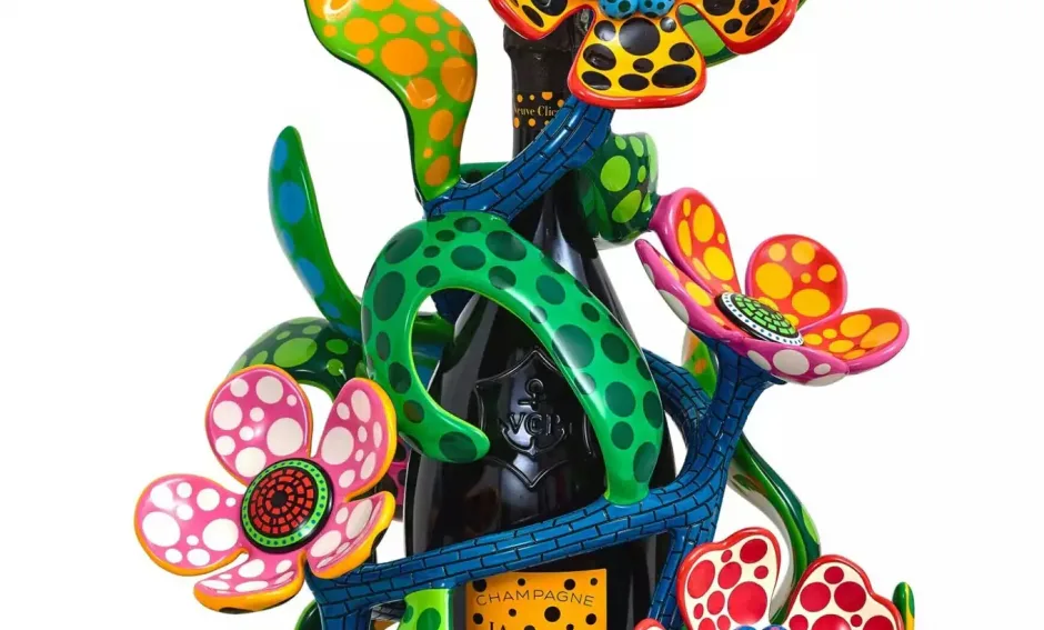 Colorful mixed-media sculptural installation featuring vibrant green, pink, yellow, and orange organic forms with polka-dot patterns intertwined around a dark central element.