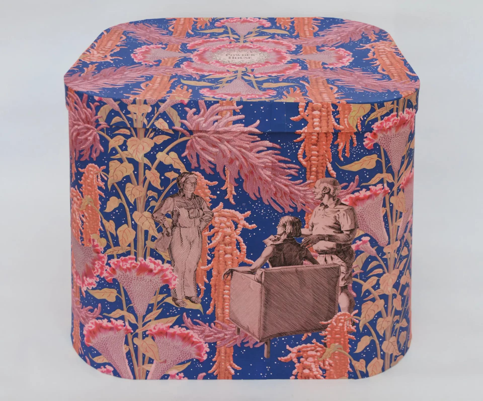 Cylindrical decorative box with ornate blue and coral patterned fabric featuring historical figures and botanical designs, embellished with golden trim.