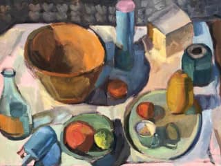 Still life painting with brown bowl, colorful bottles, fruits, and plates on white cloth; muted palette of blues, yellows, oranges, and greens.