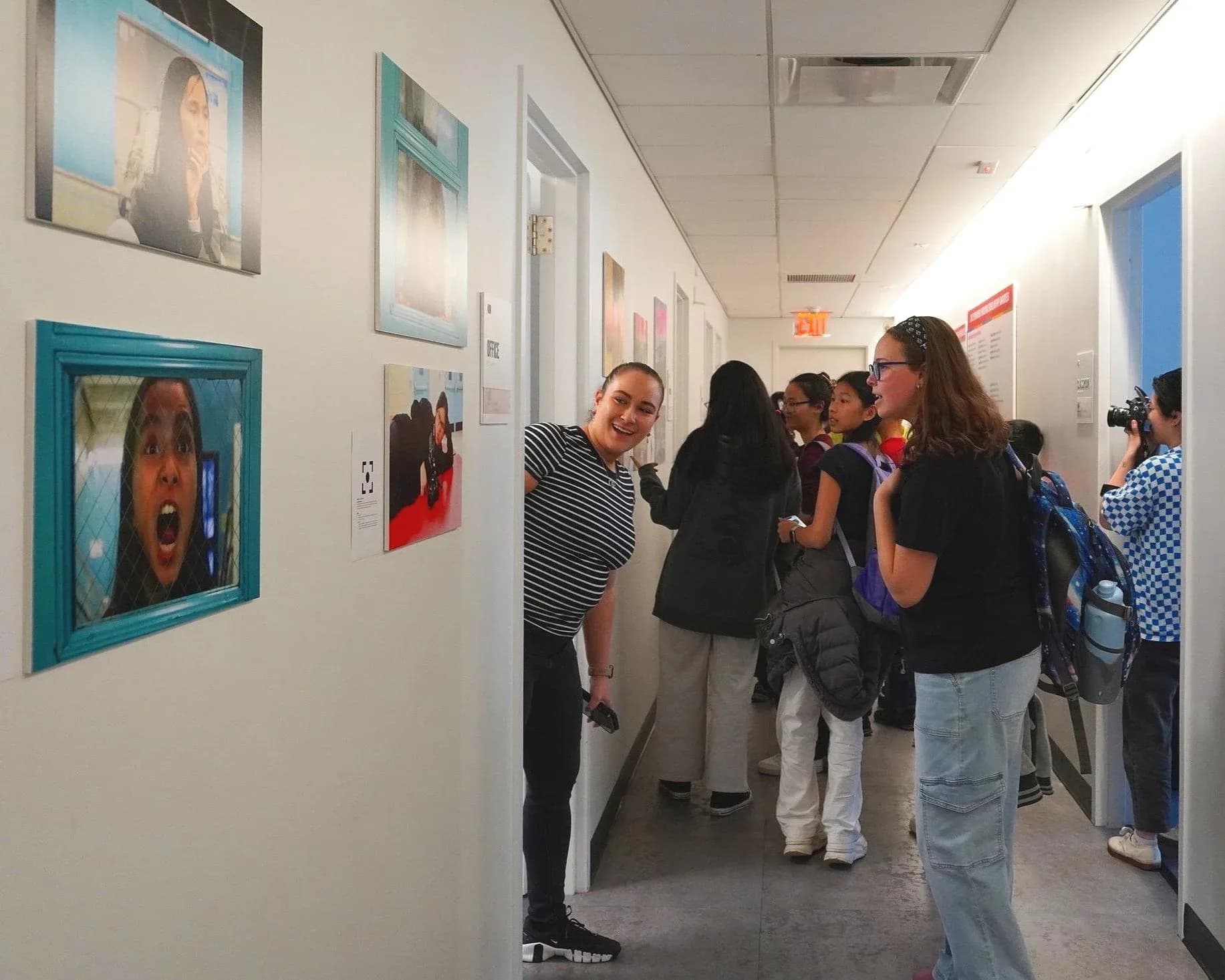 Gallery hallway at Josephine Herrick Project with framed photographs displayed on white walls; visitors viewing the exhibition.