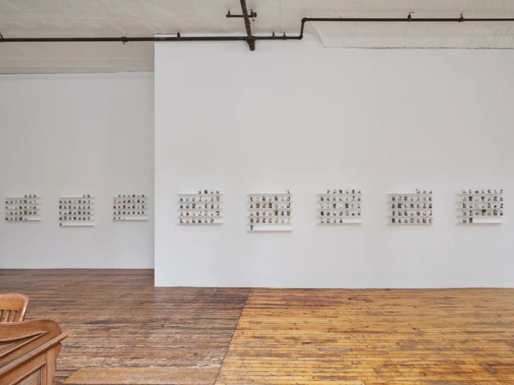 Gallery walls with eight modular arrangements of small printed squares mounted horizontally across white panels.