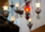 Blurred overhead shot of hanging decorative objects with warm lighting, possibly religious or ceremonial items.