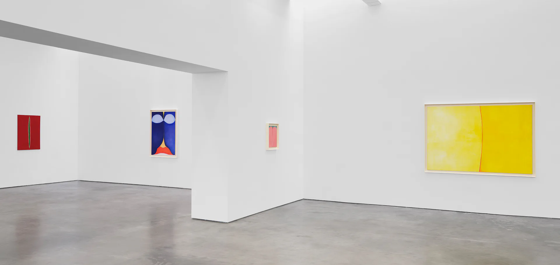 Lisson Gallery exhibition view with polished concrete floor and white walls displaying small colorful artworks—red and blue paper works on wall, bright yellow two-panel painting on right.