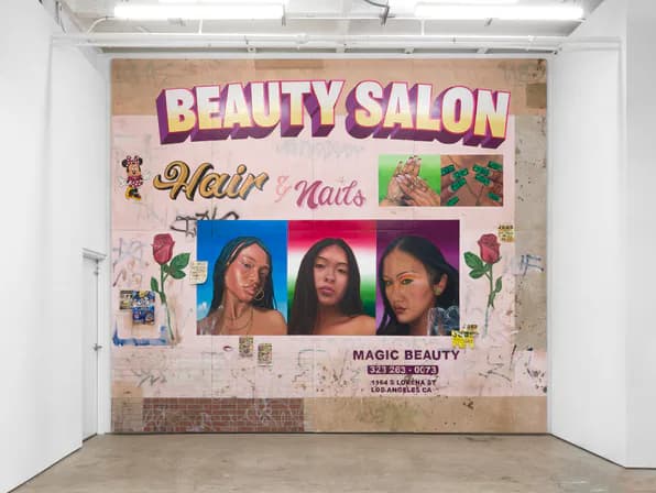 Gallery wall installation featuring large Beauty Salon signage with photographs, text, and collaged elements on brick.