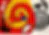 Small, heavily pixelated or blurred image with red and yellow coloring, subject indeterminate.