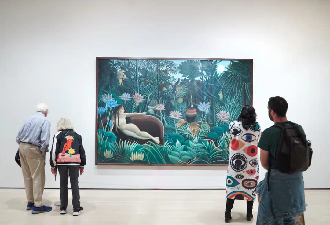 Museum gallery interior with visitors viewing a large painting of a reclining figure in a jungle landscape with blue and green tones on white wall.