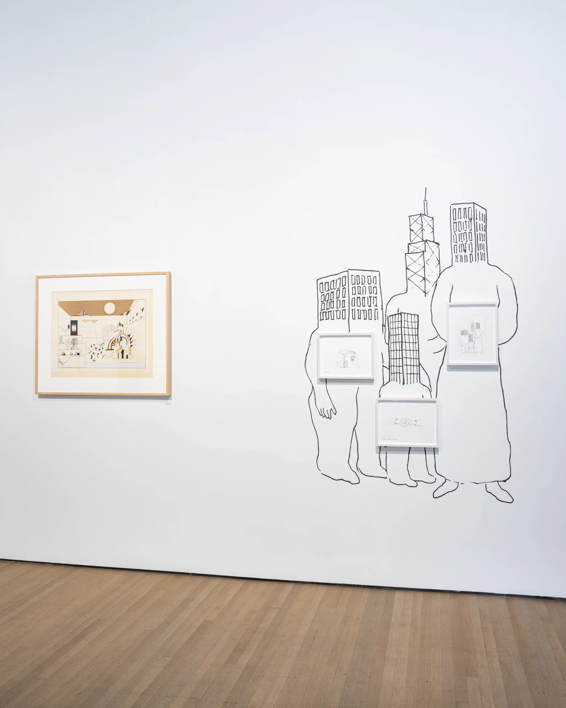 Gallery wall displaying small framed drawing on left and large-scale line drawing of figures with architectural elements on right, wooden flooring.