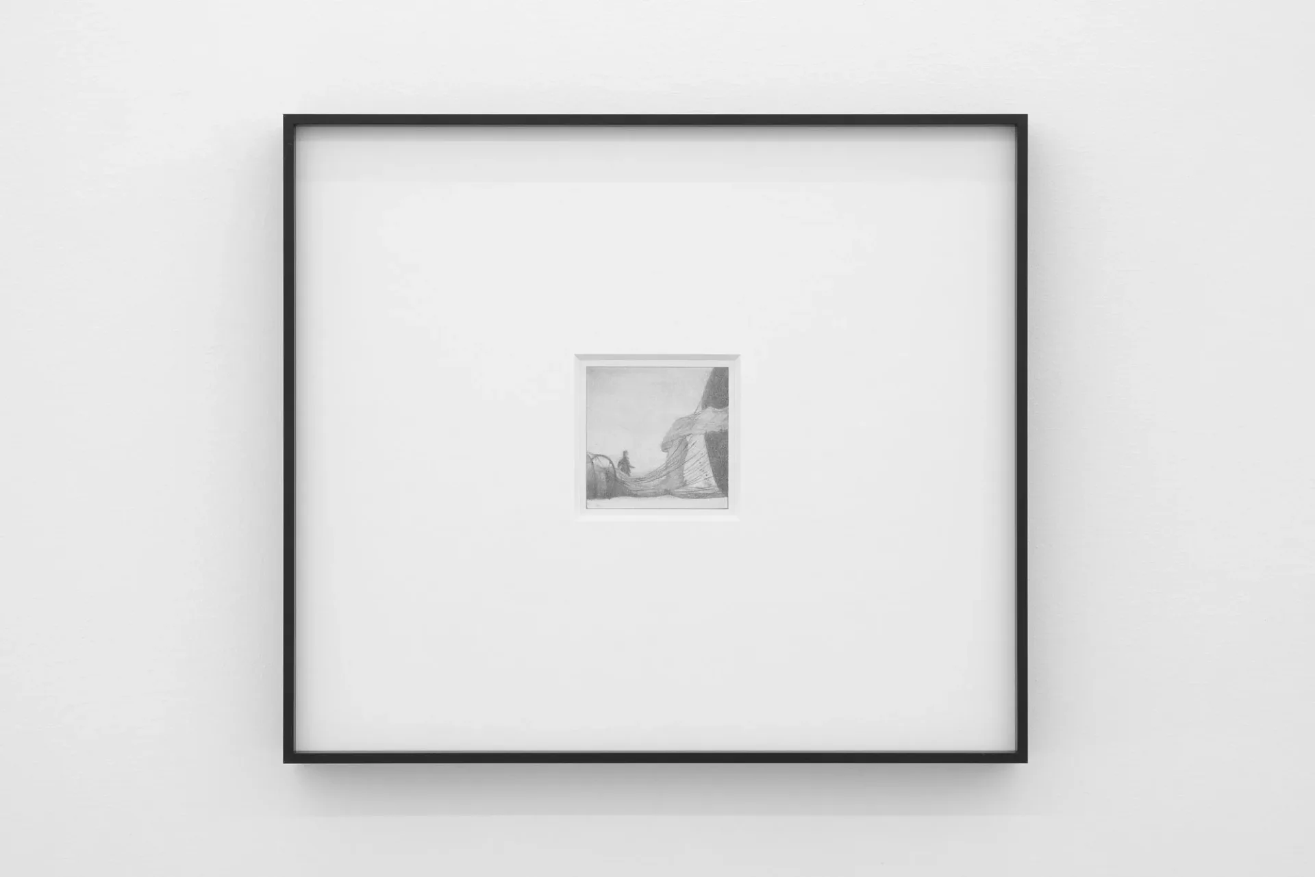 Gallery wall with black frame displaying a small framed photograph or artwork centered on white matting.