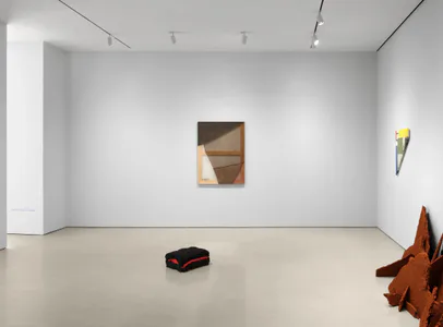 Peter Blum Gallery white interior with polished concrete floor displaying three artworks: small wall-mounted painting, minimal sculpture on floor, and rust-colored metal form.