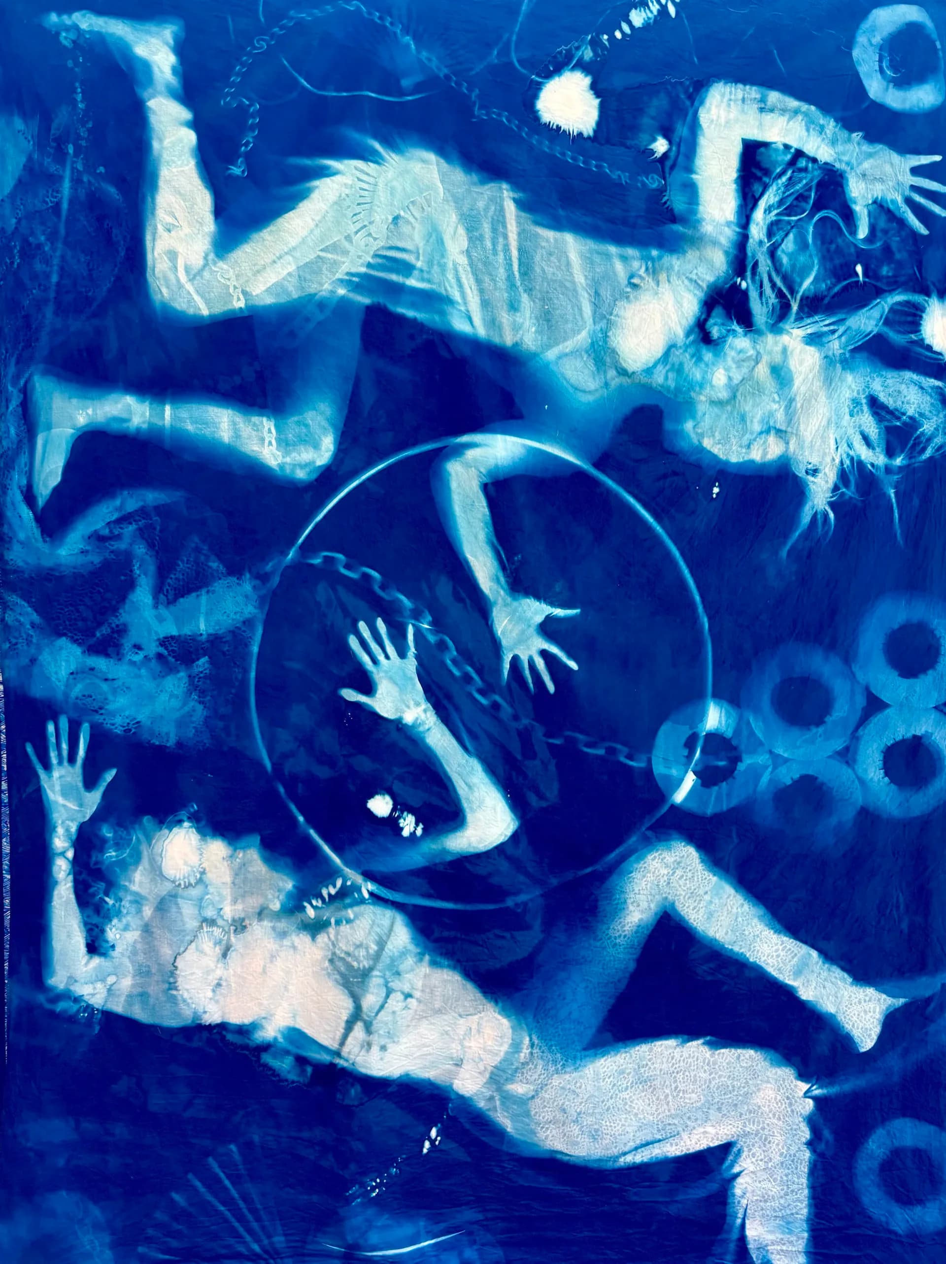 Abstract cyanotype or light-sensitive print in bright blue and white featuring overlapping human figures, hands, and circular geometric forms.