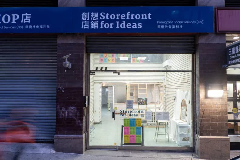 PROTOCINEMA storefront with blue Chinese signage reading 'Storefront for Ideas' above the entrance, interior visible through glass with white walls and artwork.