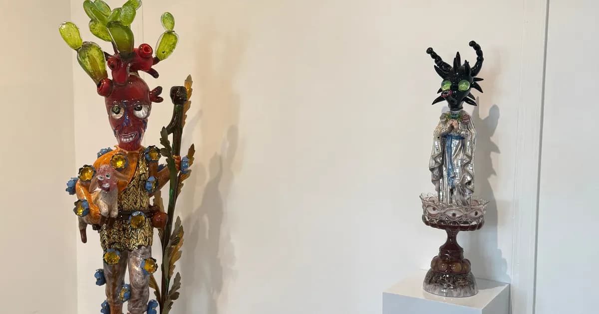 Two tall sculptural totem-like mixed-media artworks on white pedestals, featuring stacked colorful forms with organic shapes and dark decorative elements.