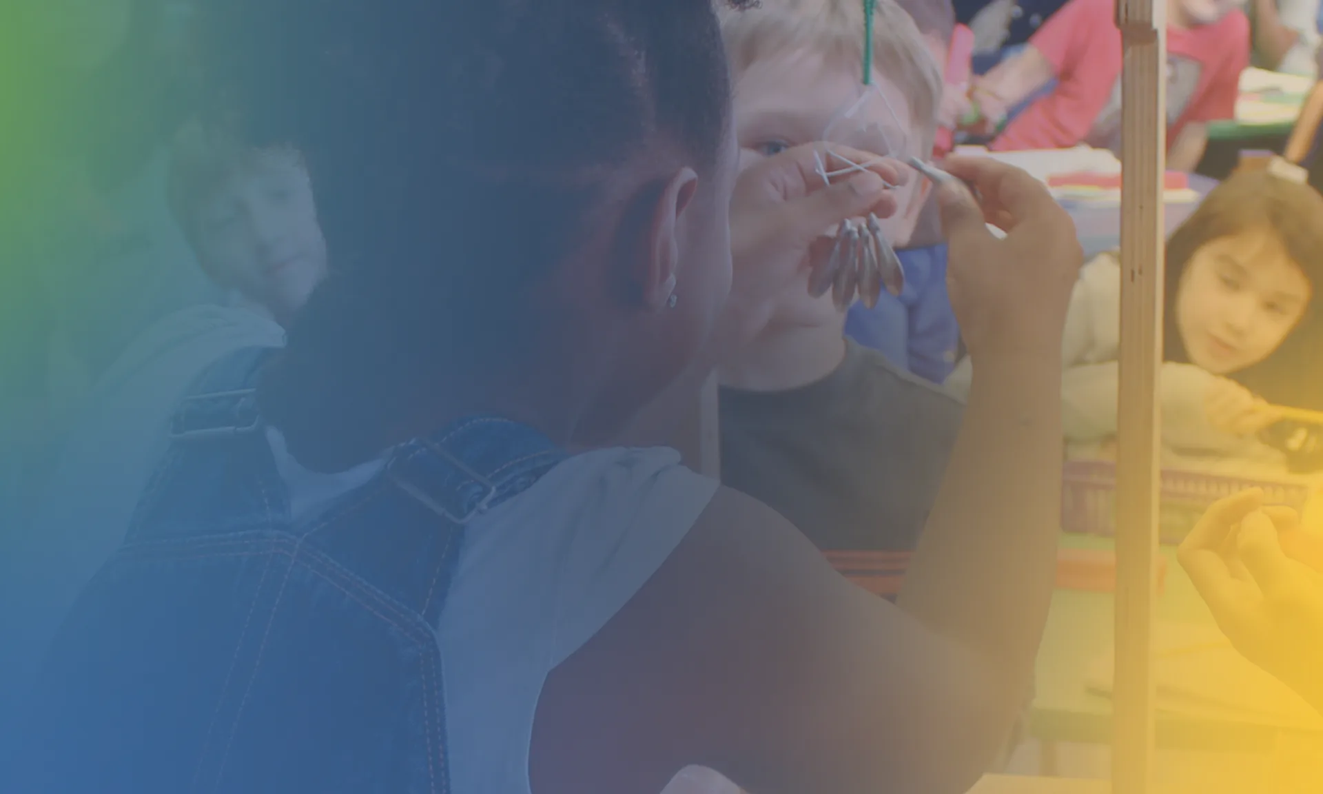Blurry, heavily color-filtered image of people engaged in hands-on activity; details obscured by overlay effects.
