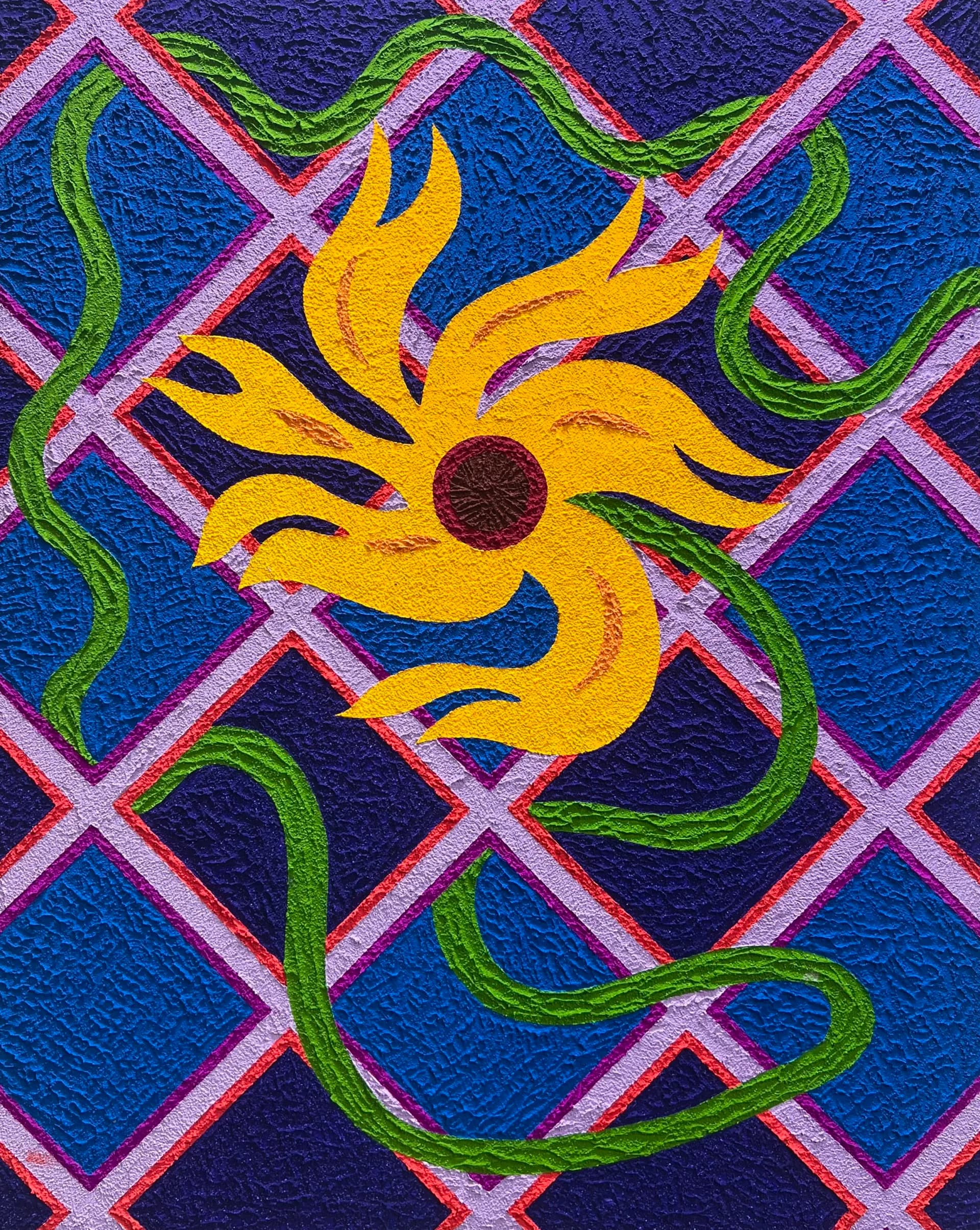 Mural painting featuring a bright yellow sun with dark petals and brown center, surrounded by twisting green vines, set against a deep blue background with pink diamond lattice pattern.