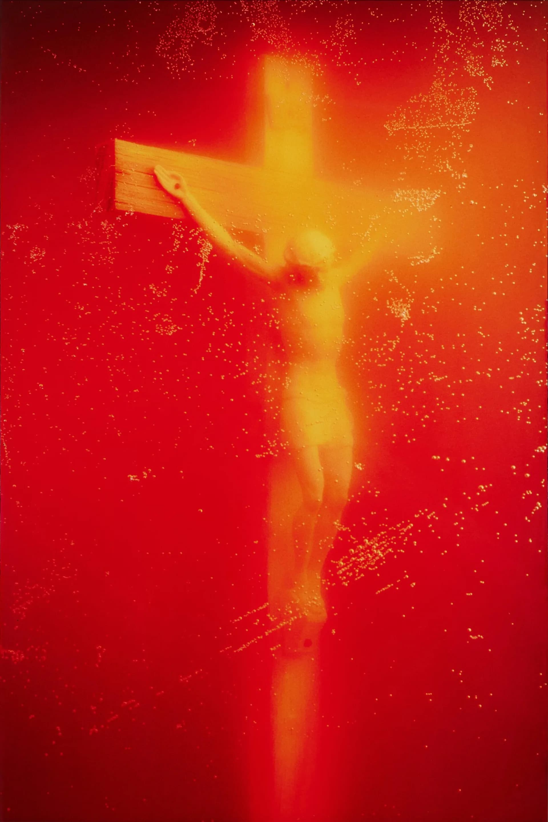 Abstract thermal or heat-map style image of a crucifix figure rendered in glowing yellow, orange, and red tones against deep red background.