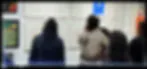 Blurry photograph of people in an interior space; image quality too low for clear identification.