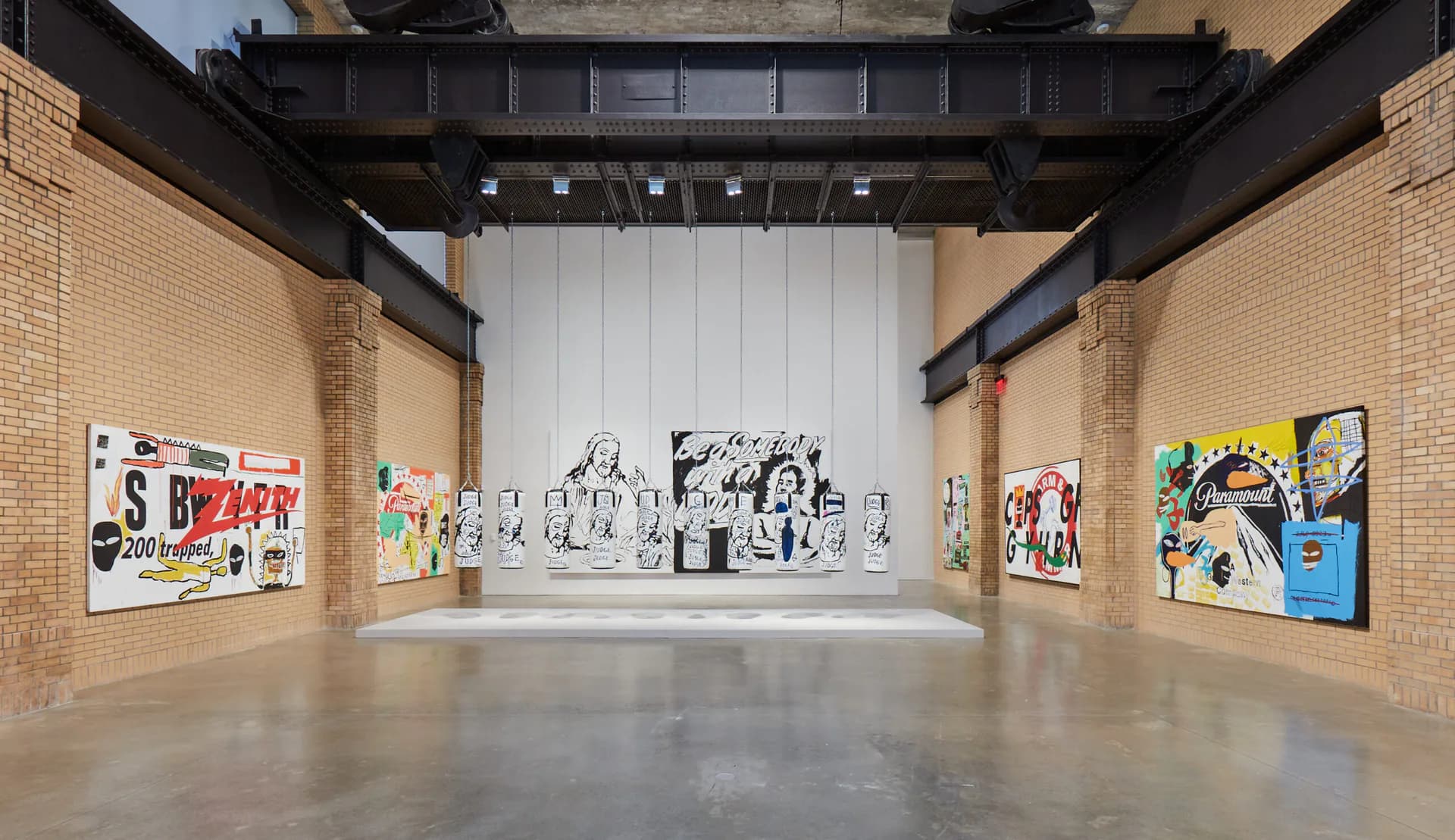 Gallery interior at The Brant Foundation Art Study Center with brick walls, concrete floor, and various artworks displayed on white and brick surfaces under professional lighting.