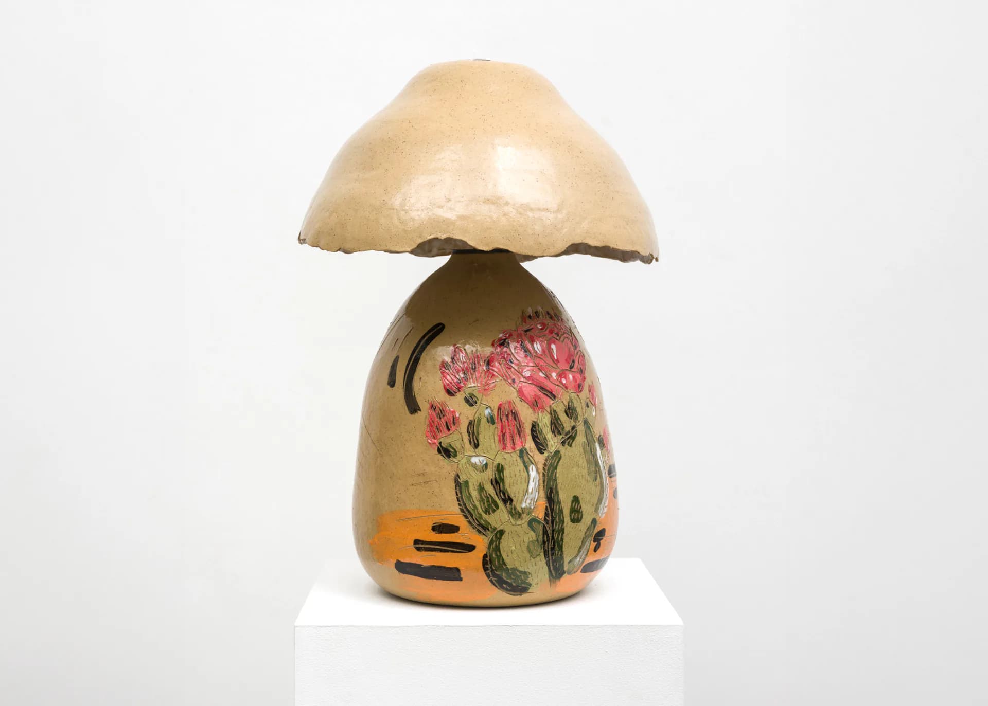 Ceramic sculpture of a mushroom with a cream-colored cap and tan bulbous base decorated with pink flowers, green leaves, and orange accents.