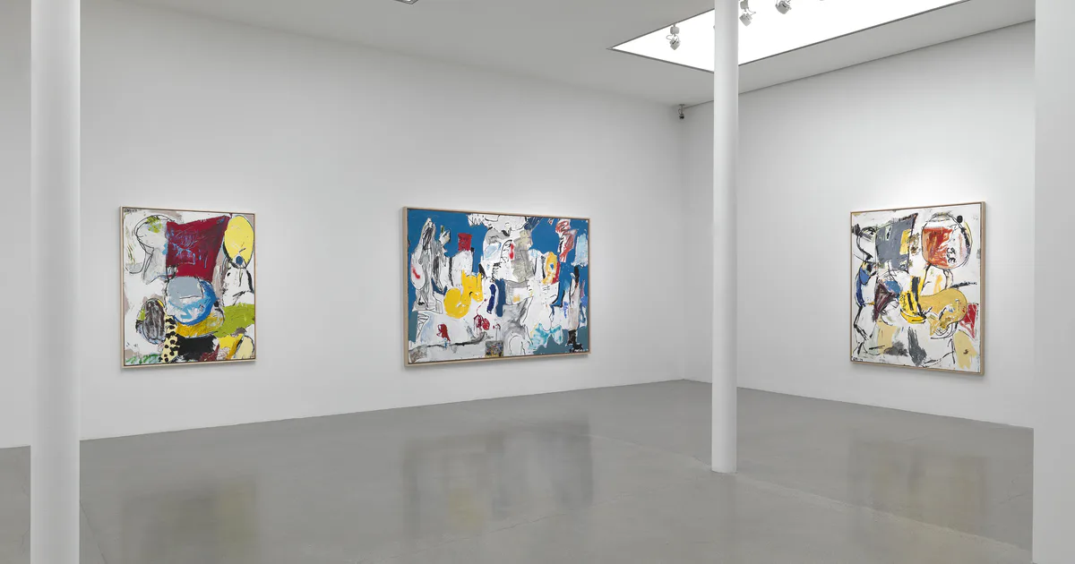 Gallery interior with white walls, skylight, and three colorful abstract paintings on display
