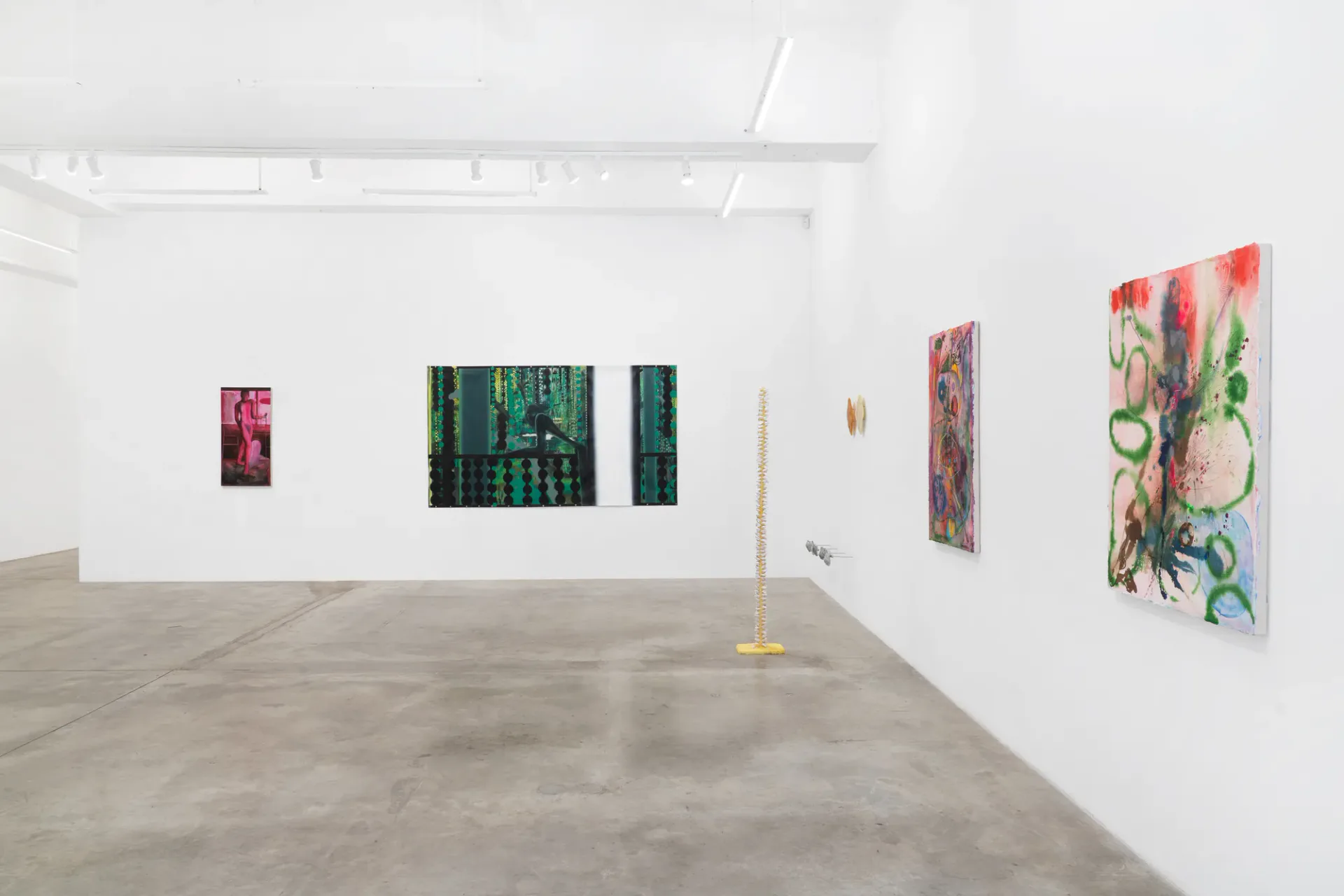 Gallery interior at Tina Kim Gallery with white walls, smaller colorful abstract artworks displayed on walls, minimalist presentation in polished concrete space.