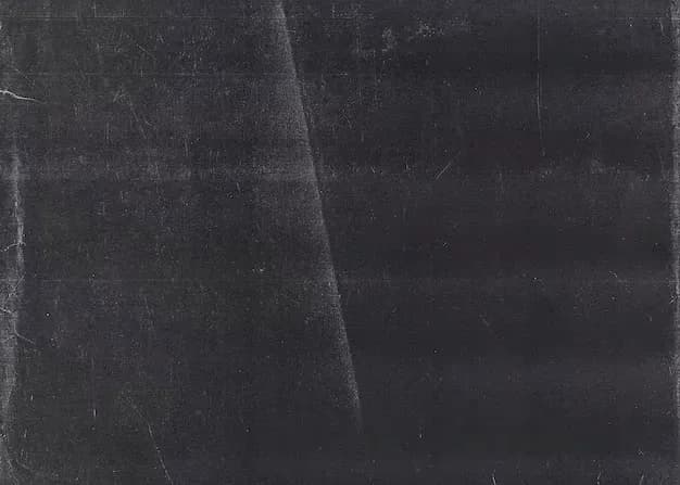 Dark textured surface with scratches and marks, resembling a chalkboard or worn slate background.