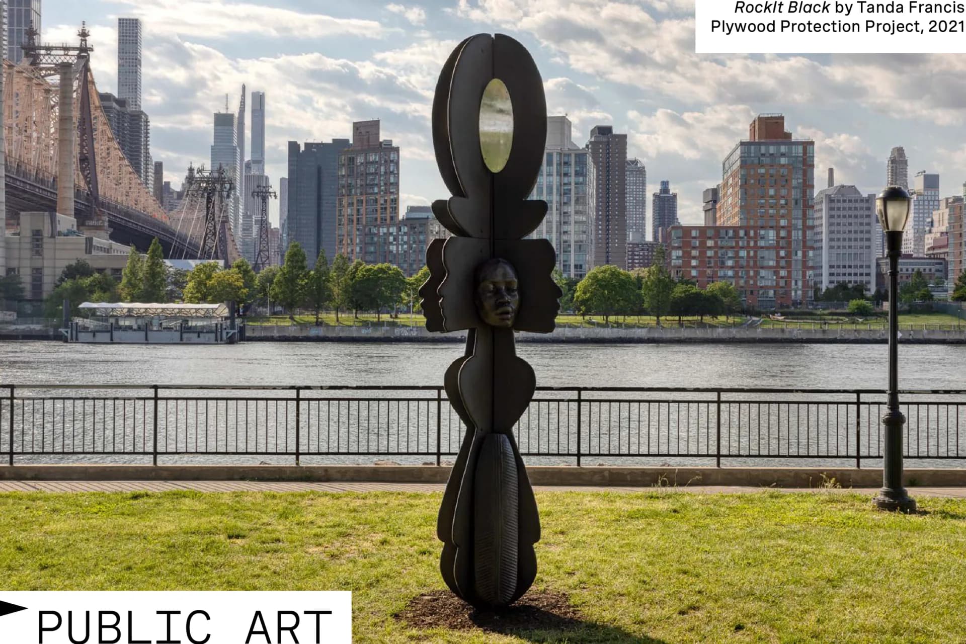 Rocket Block, abstract black sculptural form by Tenda Francis, installed on waterfront grass with Manhattan skyline behind.